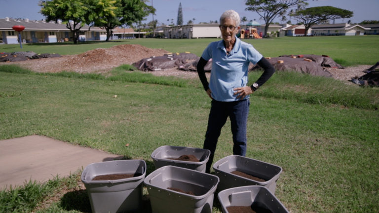 Image of Mindy standing next to bins filled with vermicast